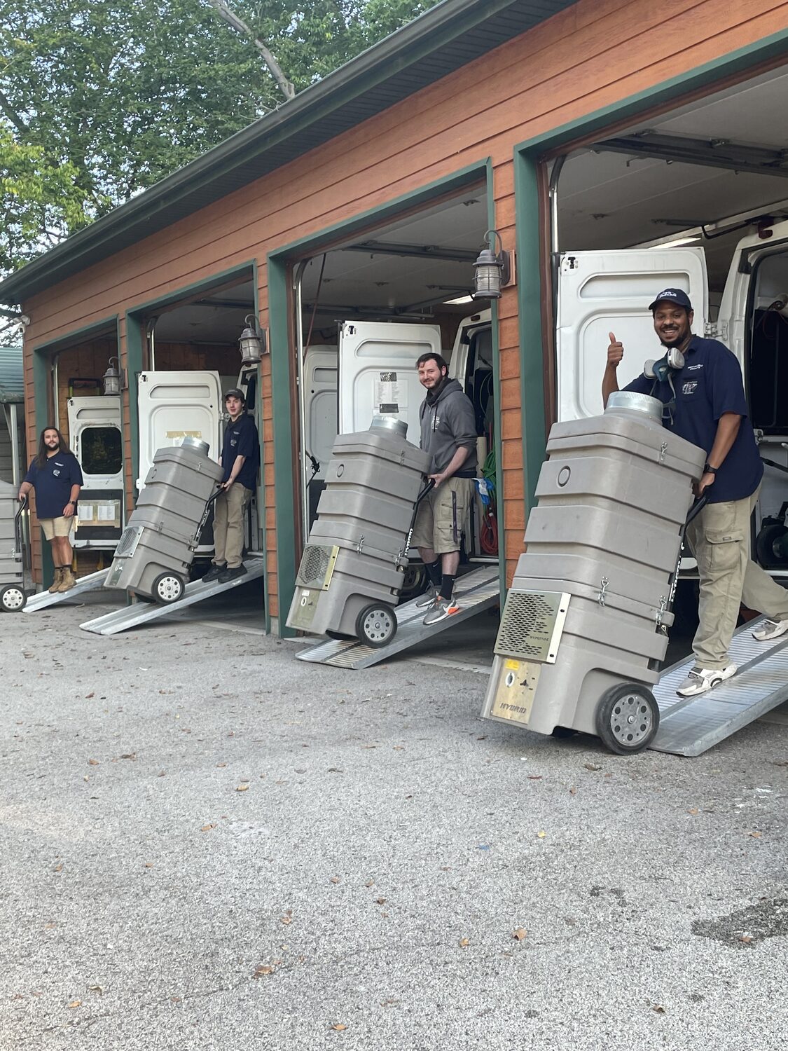 SafeAir Duct Care technicians rolling portable source-removal machines out to the vans at the start of a job